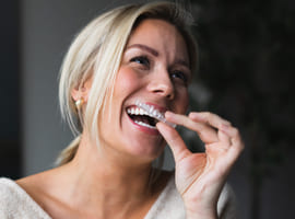 Dame med Invisalign tannreguleringsskinner, usynlig tannregulering