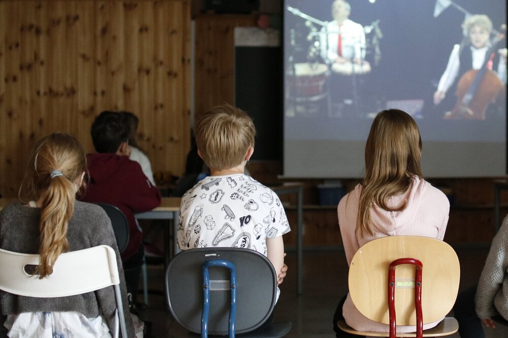 bildet tatt bakfra av elever i et klasserom som ser opp mot tavlen