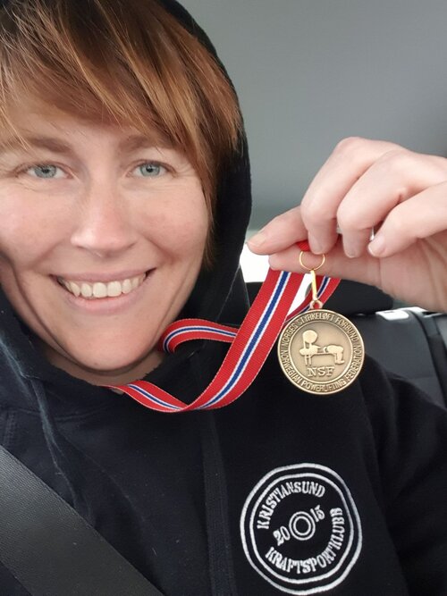 Kristiansunds kultursjef, Eigunn Stav Sætre, med medaljen hun fikk i NM i styrkeløft