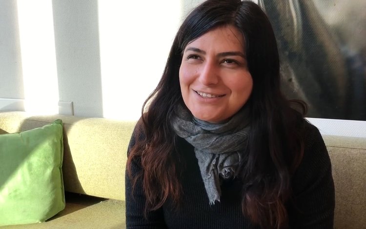 Regissør Rokhsareh Ghaemmaghami sitter smilende i sofa