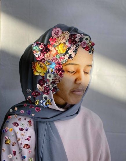 En jente med grå hijab. Hijaben er dekorert med blomster