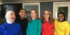 Fem jenter i fargerike hettegensere ler