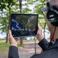 Mann med nettbrett og hodetelefoner tester "Munchs digitale hage"