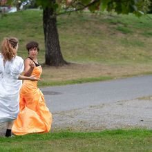 To kvinner i kjole løper på en gressplen