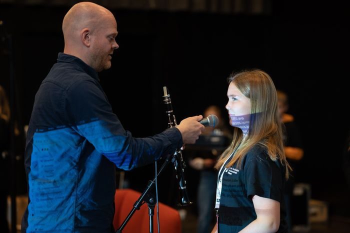 en mann holder en mikrofon mot ei jente