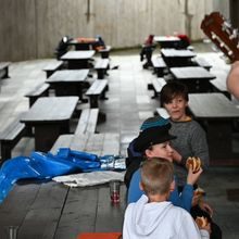 en mann spiller gitar mens fire elever spiser fiskekaker