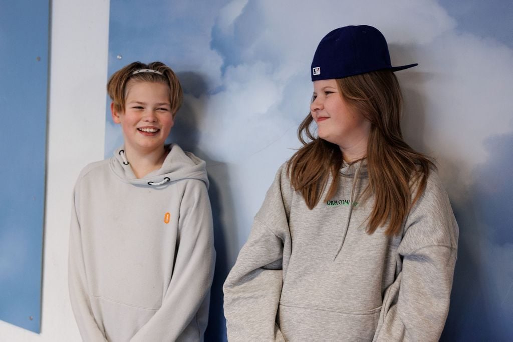 Elevene Max og Milla lener seg inntil en vegg.
