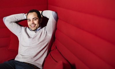Integrering og inkludering: Mann med grå genser sitter tilbakelent i en stor, rød sofa.