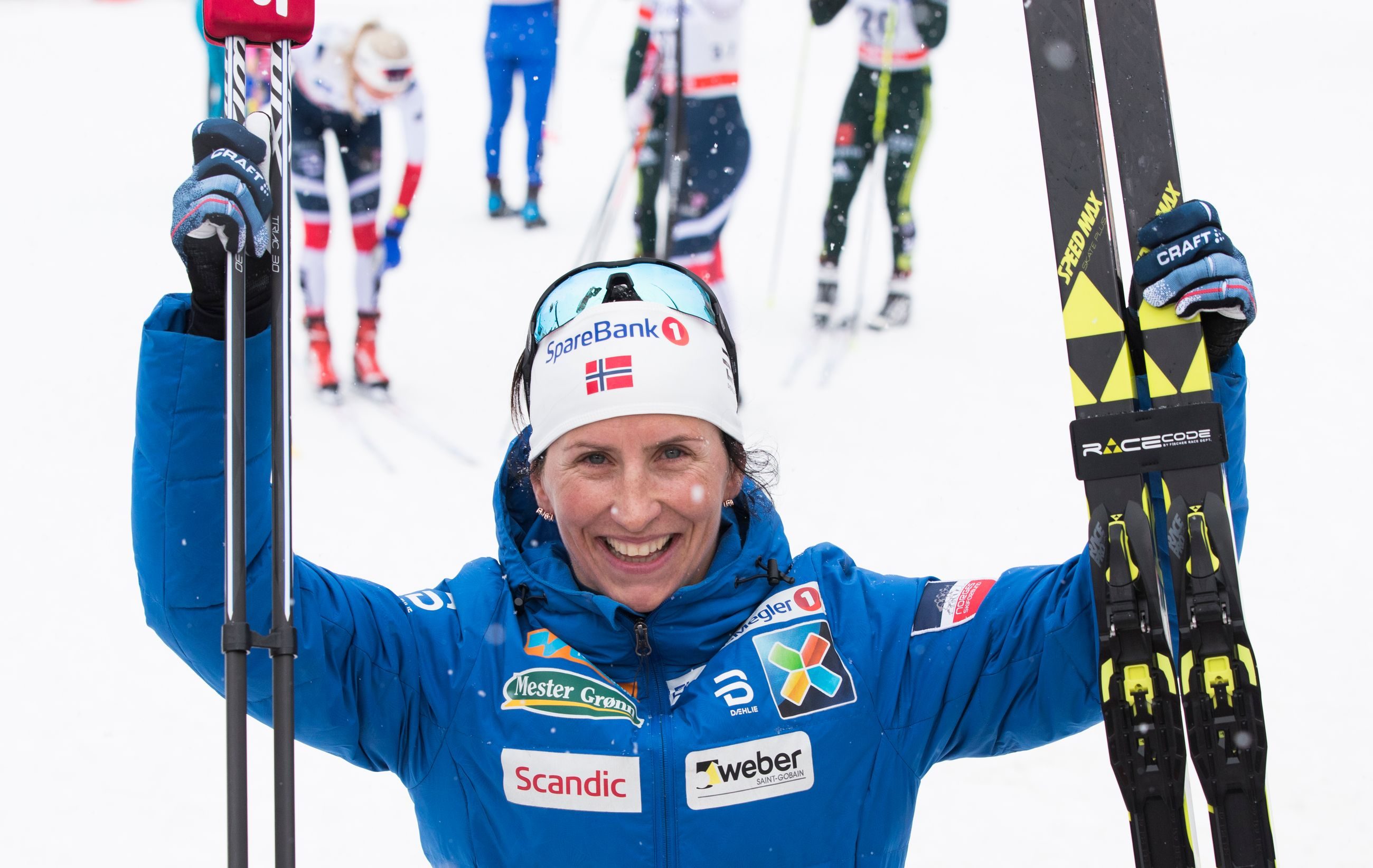 Visualisering - Marit Bjørgen smiler mens hun older opp ski og staver etter seiersløp.