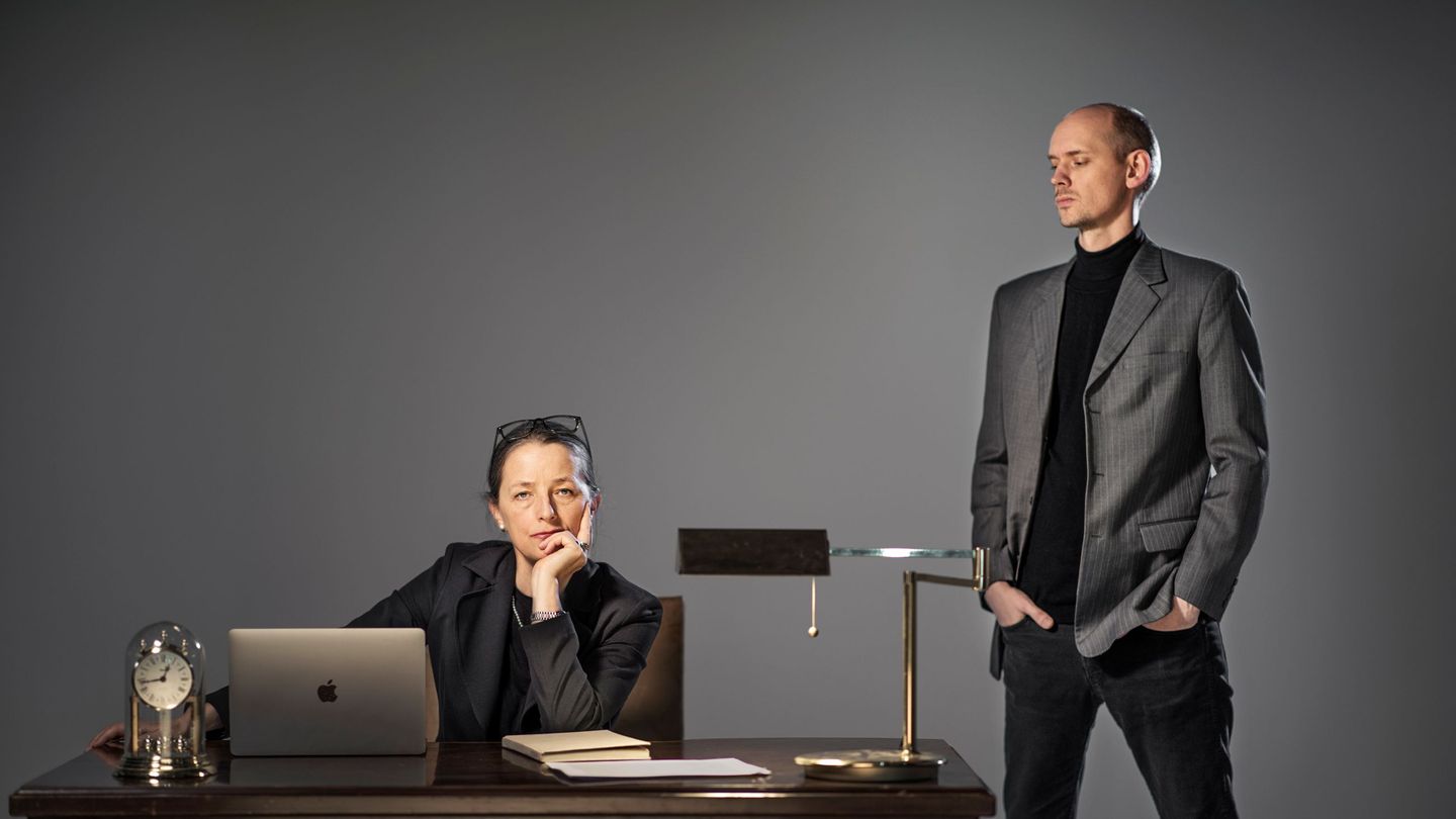 Frykt på jobben: Streng kvinne siter bak et gammelt skrivebord, en nedlatende mann står ved siden av.