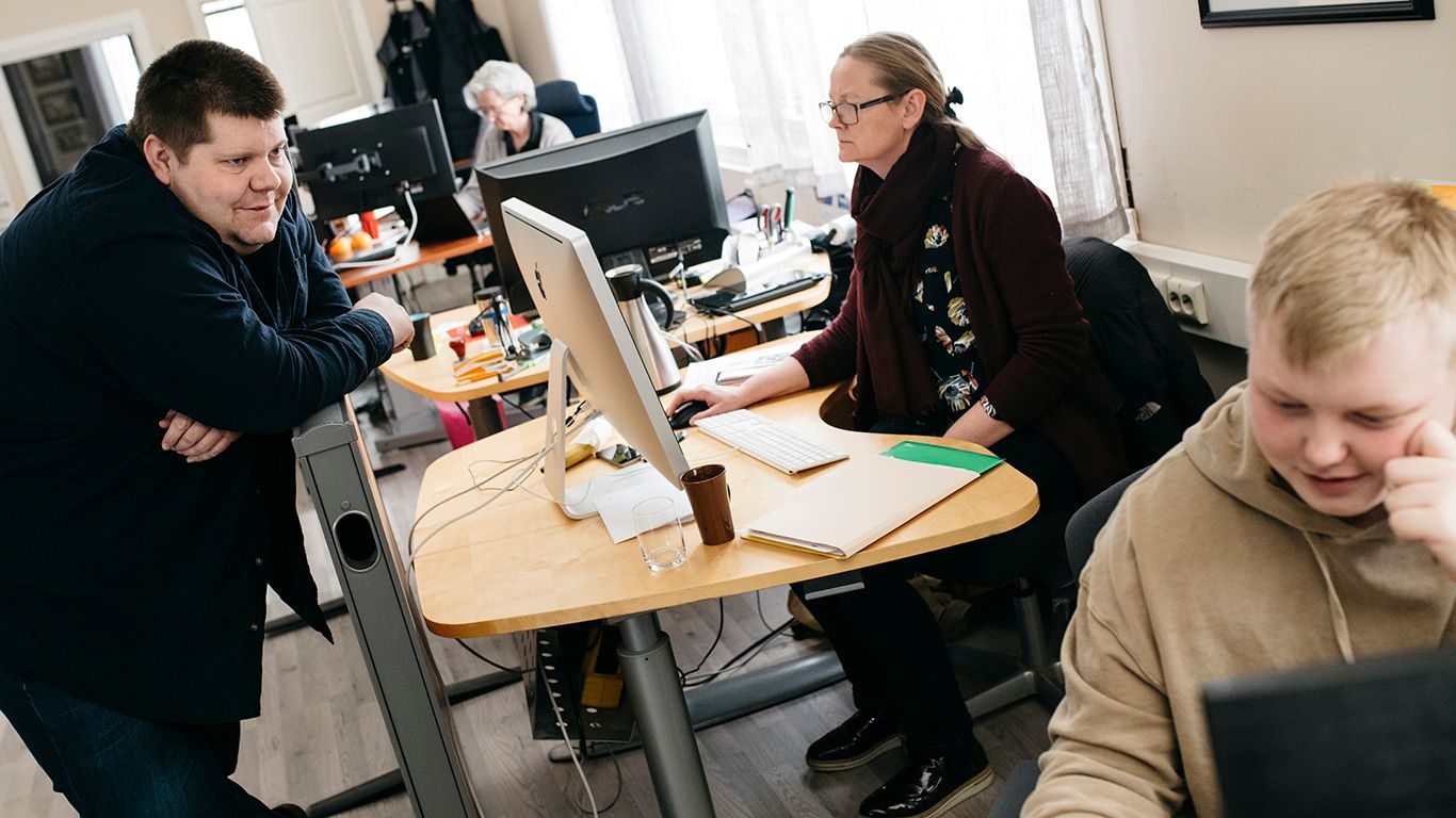 Salangen Nyheter: En mann, to kvinner og en ung mann i et redaksjonslokale.