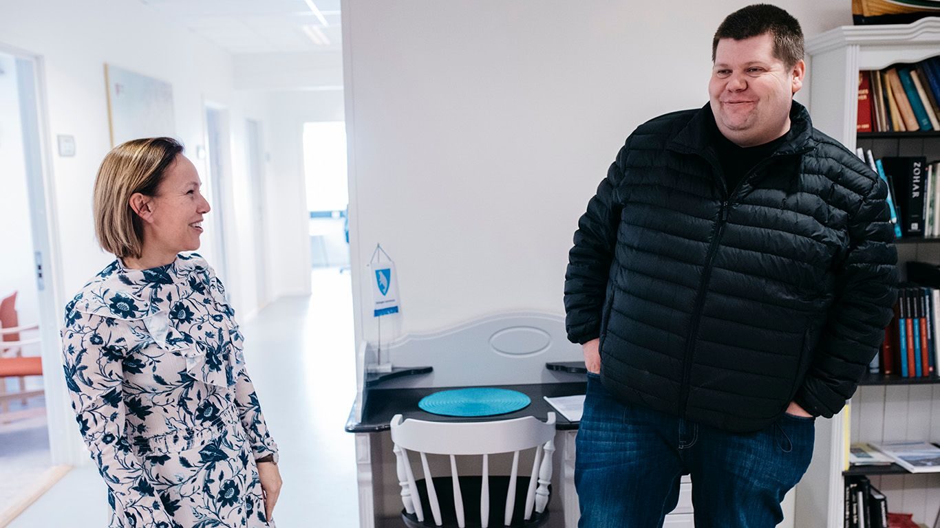Salangen Nyheter: Kvinne og manne snakker sammen i et kontorlandskap.