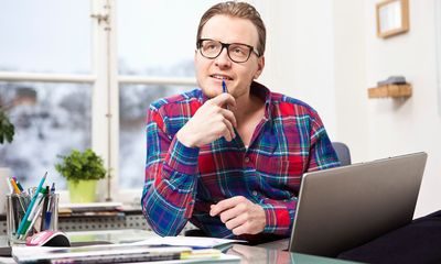 Motivasjon: Mann med briller sitter og tenker ved skrivebordet.