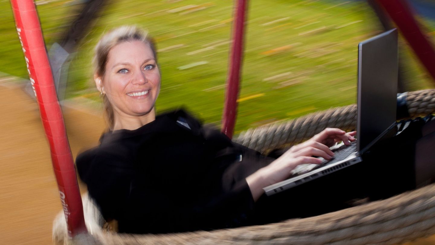Lønnsomhet: En kvinne sitter i en stor huske med en laptop på fanget.