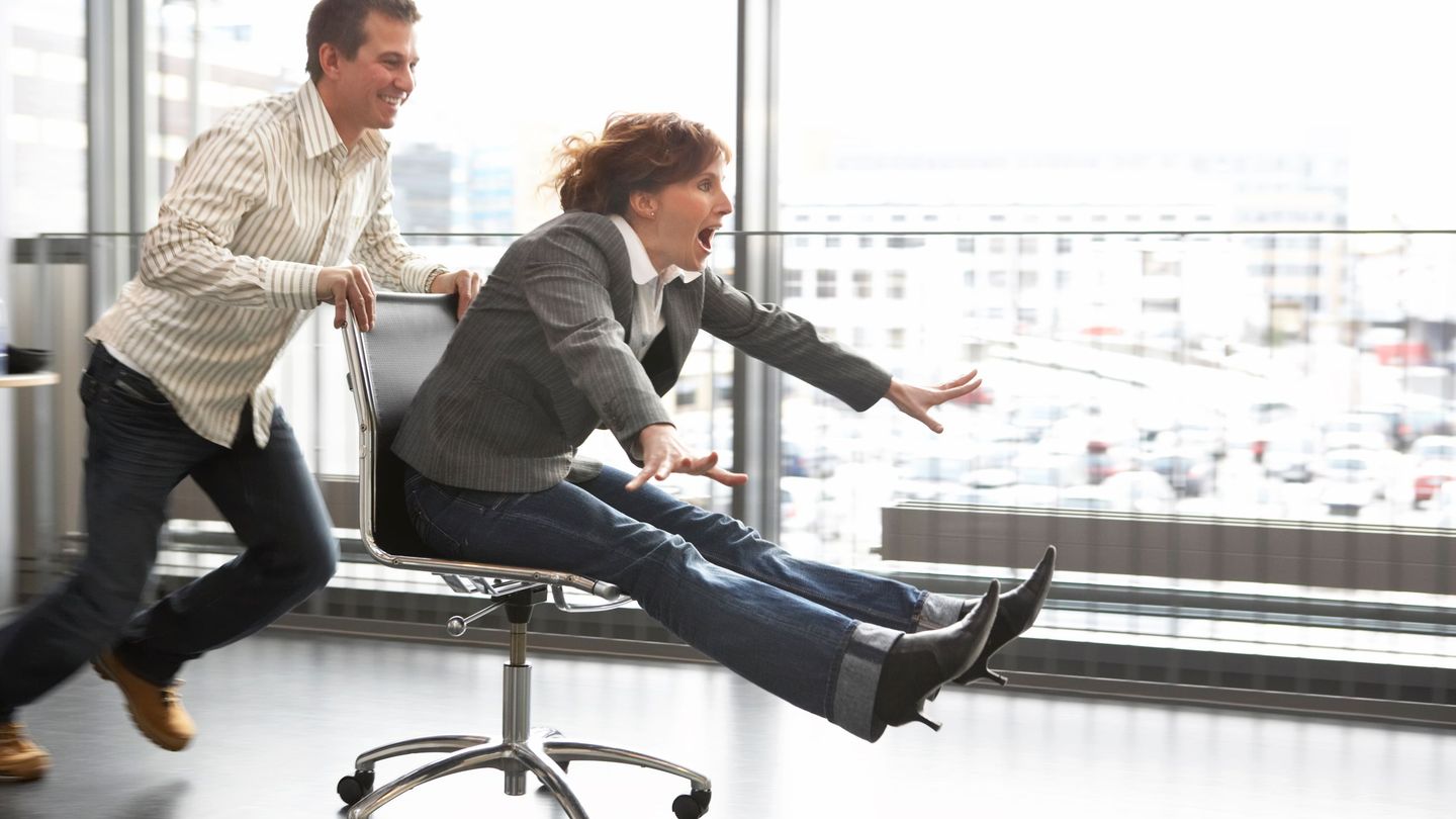 Humor: En mann dytter en kvinne i kontorstol i stor fart.