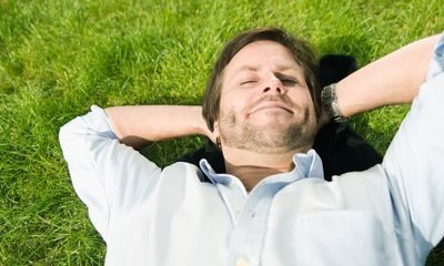 Pauser: Mann ligger i gresset og slapper av.