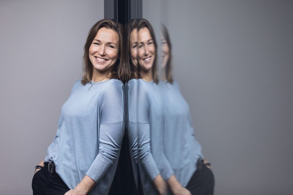 Lederskap: Kvinne med lyseblå genser står lent mot et speil.