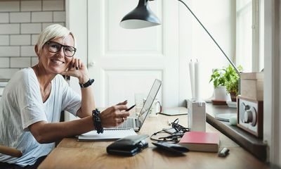 Fleksibilitet: Blid kvinner sitter og jobber hjemme med PC-en foran seg.