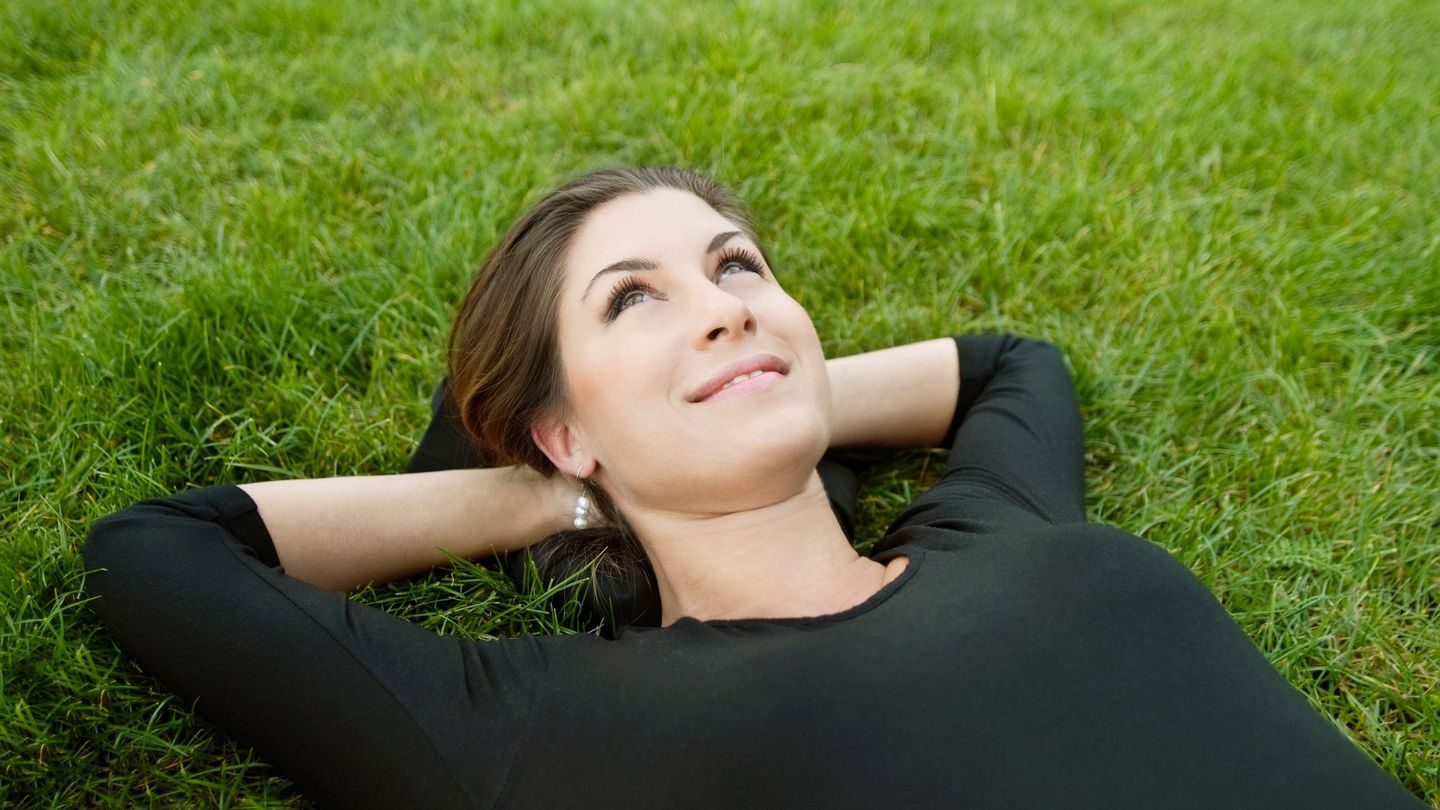 Pauser: Kvinne slapper av i gresset.