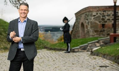 Forsvaret: Smilende mann står ute på Akershus Festning med en gardist i bakgrunnen.