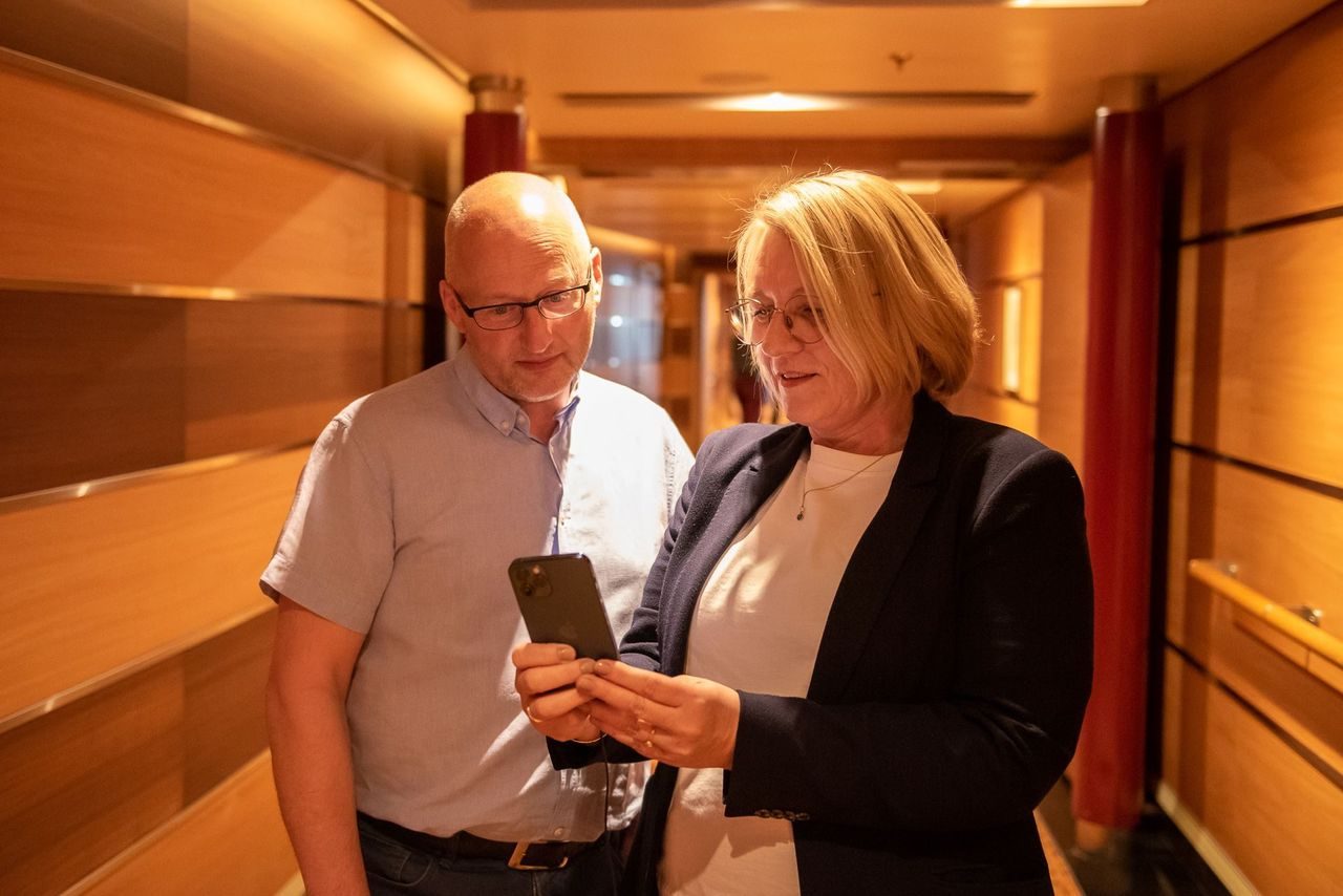 Mann og en dame i 50 årene ser på en mobil