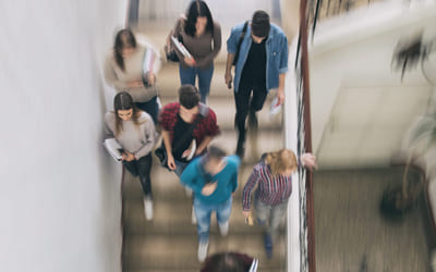Illustrasjonsbilde av elever sopm går ned trapp. Foto: iStock.