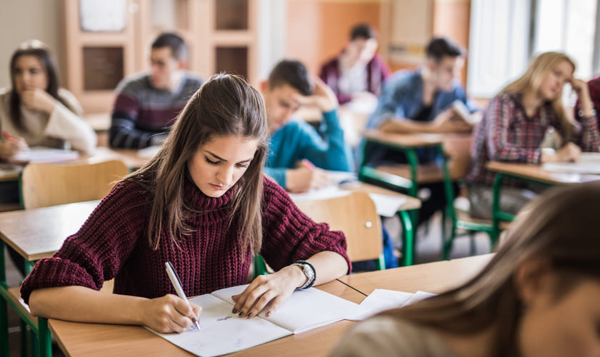 Illustrasjonsbilde av videregående-elever i et klasserom som har en skriftlig prøve. Foto: Istock.