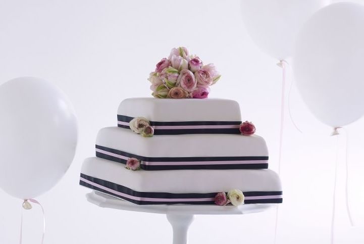 Bride Putting Finishing Touches On Cake