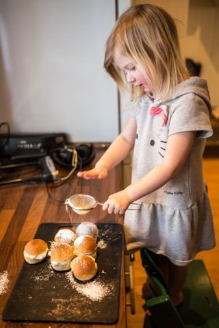 Jente som drysser melis på fastelavnsboller