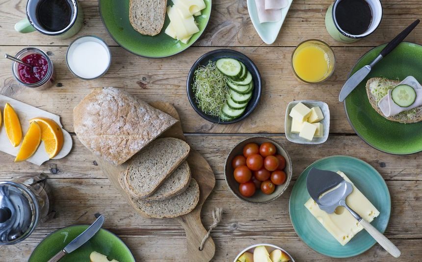 Frokostbord med grovbrød, ost, skinke, frukt og grønnsaker