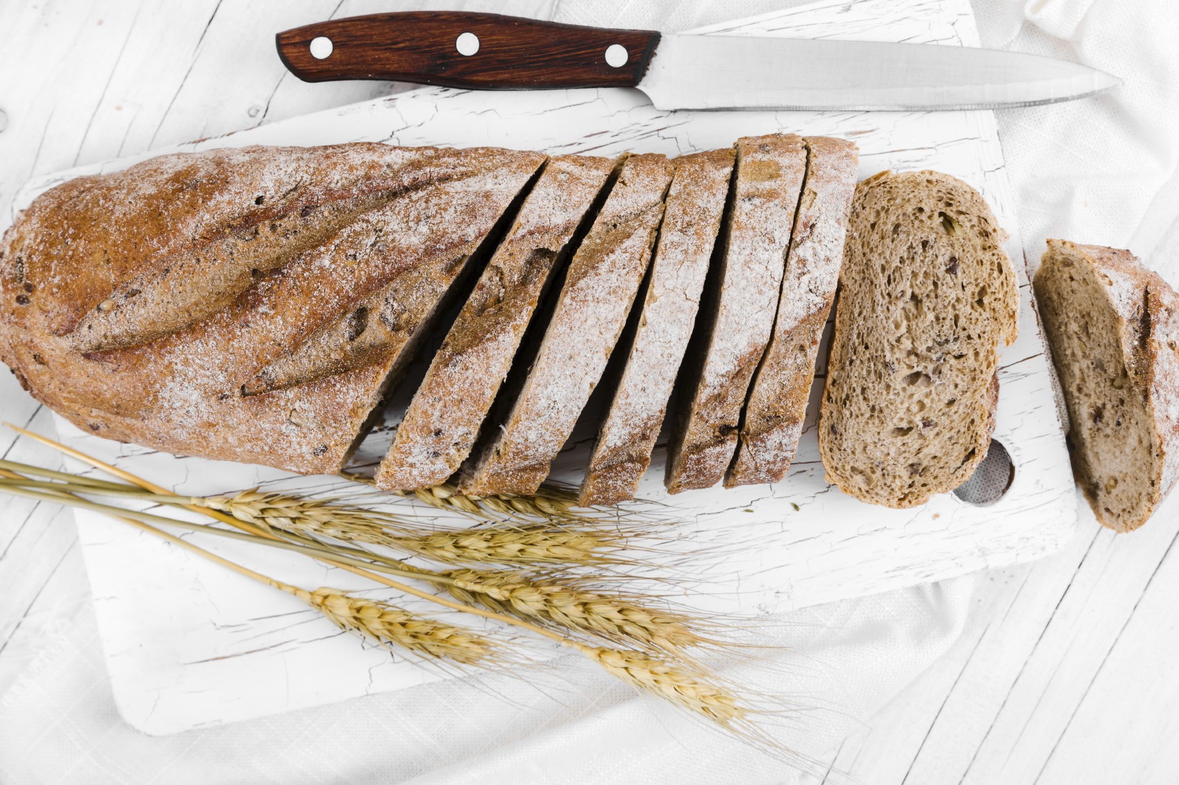Grovt brød på en fjøl. Grovbrød er superbillig supermat, og en viktig kilde til fiber, protein, langsomme karbohydrater, og viktige næringsstoffer og mineraler.