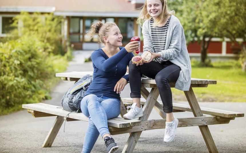 Marte og Mathilde spiser lunsj i skolegård