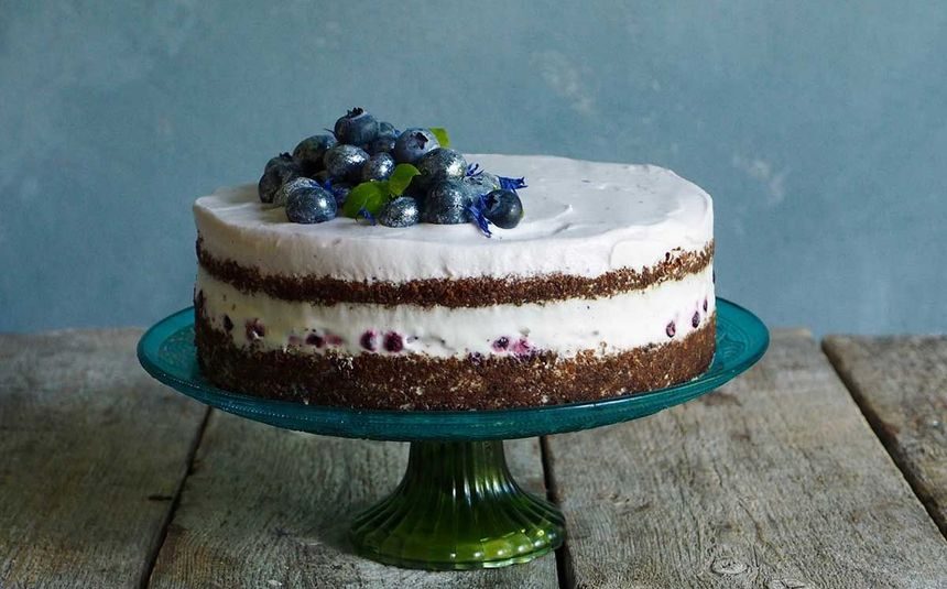 Rugbrødlagkake med grove smuler av rugbrød i deigen, friske bær og en silkemyk ostekrem