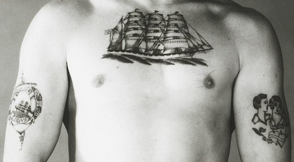 ett mansbröst med en tatuering av en båt