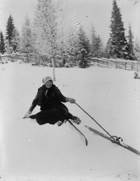 kvinna med skidor som ramlat i snön