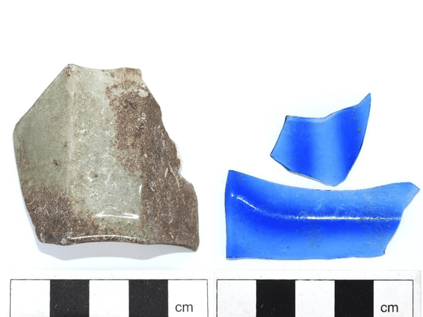 Ett fragment från ett åttkantigt, grönt passglas och ett glasfragment i blå färg.