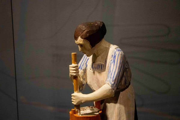 En snidad träfigur av en kvinna med en smörkärna. 